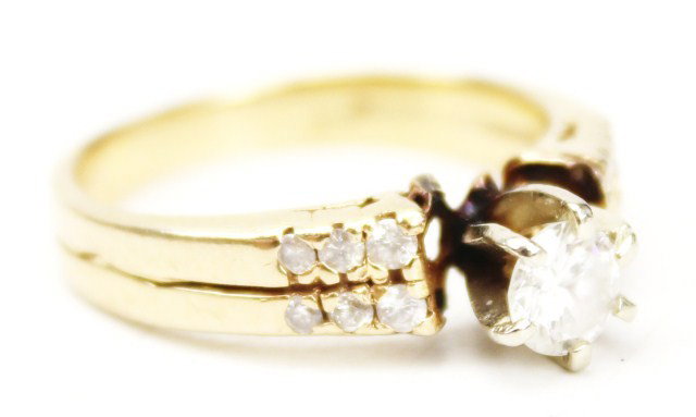 LADIES 14K GOLD AND DIAMOND RING: LADIES 14K GOLD AND DIAMOND RING Two 14K yellow gold bands have been fused to create this diamond ring. A center solitaire of approximately SI1 quality and H color. 6 accent diamonds lie in a channel 