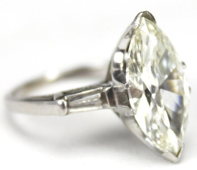 LADIES PLATINUM 5 CARAT MARQUISE DIAMOND RING: LADIES PLATINUM 5 CARAT MARQUISE DIAMOND RING Stunning 5 carat marquise diamond set in a platinum solitaire setting. Approximately K color and SI-1 clarity. Accented by 2 baguette diamonds of approxim