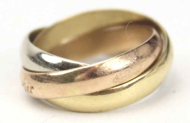 LADIES 18K GOLD CARTIER PUZZLE RING: LADIES 18K GOLD CARTIER PUZZLE RING Three bands are bound together in a puzzle-like fashion. Two of the bands are yellow gold and the third is white gold. All three bands are 18K gold. One of the band