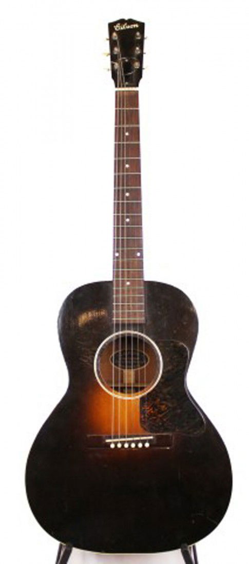 1933 GIBSON L-50 ACOUSTIC GUITAR: 1933 GIBSON L-50 ACOUSTIC GUITAR Acoustic guitar by Gibson. Produced in 1933. Replaced bridge. The guitar is in good used condition with minor scratches to the body. Inset 'Gibson' to the head. Size: