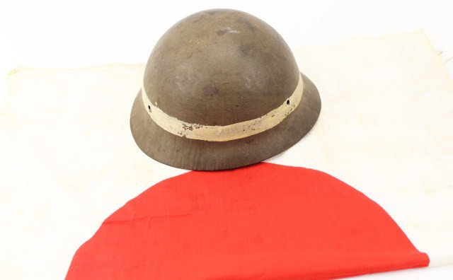 WORLD WAR II JAPANESE HELMET SHELL AND COTTON FLAG: WORLD WAR II JAPANESE HELMET SHELL AND COTTON FLAG World War II Japanese military helmet shell, painted for military police use with broad white stripe. No liner or front badge. The inner shell shows 