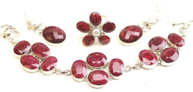 LADIES STERLING SILVER & RUBY JEWELRY LOT: LADIES STERLING SILVER & RUBY JEWELRY LOT Sterling silver and ruby jewelry. Flower ring with 5 rubies and a blister pearl, 17.36 Ctw and a replacement value of $8,437. Drop style earrings each with a 