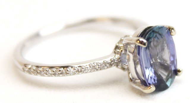 LADIES 14K WHITE GOLD TANZANITE & DIAMOND RING: LADIES 14K WHITE GOLD TANZANITE & DIAMOND RING Oval cut tanzanite of approximately 1.9 cts in a solitaire setting with over 30 small diamonds along the band. Weight: 2.7g Size: 6.5 Condition: VGC Est.