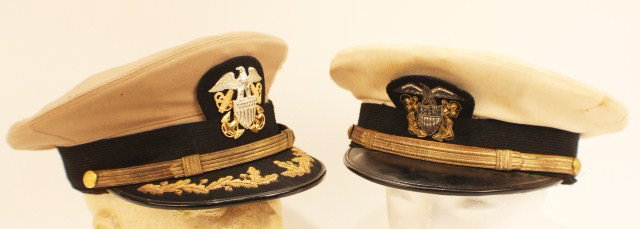 HEADGEAR - WW2 US NAVY OFFICERS VISOR CAP LOT OF 2: HEADGEAR - WW2 US NAVY OFFICERS VISOR CAP LOT OF 2 Light tan and white dress hats with bi-metal badges. Minor moth, slight staining. Sweat band liner unattached on the tan cap. Will fit head size of a
