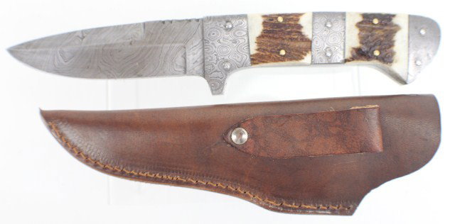 10.25" CUSTOM MADE STAG HANDLE KNIFE: 4.75" Damascus steel blade, matching scales inter spaced with stag antler sections. Contained in a hand made leather sheath. Condition: almost as new.
