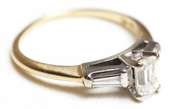 LADIES 14K YELLOW GOLD DIAMOND ENGAGEMENT RING: LADIES 14K YELLOW GOLD DIAMOND ENGAGEMENT RING Elegant 14K yellow gold band featuring a 0.5 ct emerald cut diamond accented by 2 baguette diamonds. Approximately G color and SI clarity. Weight: 2.3g S