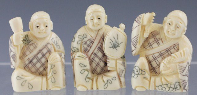 3 CARVED IVORY NETSUKE MEN: 3 CARVED IVORY NETSUKE MEN Three ivory Netsuke figures. All three men are sitting but holding different items. One man is holding a goblet, another a paddle, and the third is holding a knife and a fis