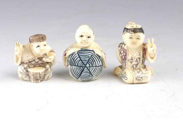 3 IVORY CARVED NETSUKE MEN: 3 IVORY CARVED NETSUKE MEN Three elephant ivory carved netsuke men. One is sitting holding a shield or target in front of him, the second is stroking his goatee with a bongo drum between his legs, the
