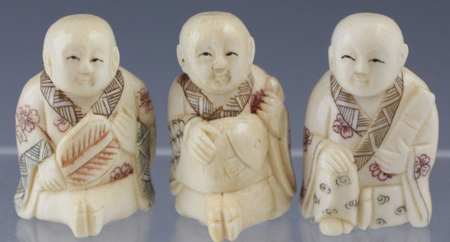 3 CARVED IVORY NETSUKE MEN: 3 CARVED IVORY NETSUKE MEN Carved mammoth ivory netsuke of seated and kneeling men holding a fan, a scroll and a fish. Size: 1.5"