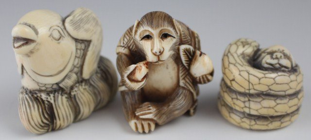 3 CARVED IVORY SIGNED ANIMAL NETSUKES: 3 CARVED IVORY SIGNED ANIMAL NETSUKES Carved clothed marking eating fruit, fish leaping out of water and a snake strangling a dog. All three are signed. Snake shows some aging in cracks. Size: .75 - 1