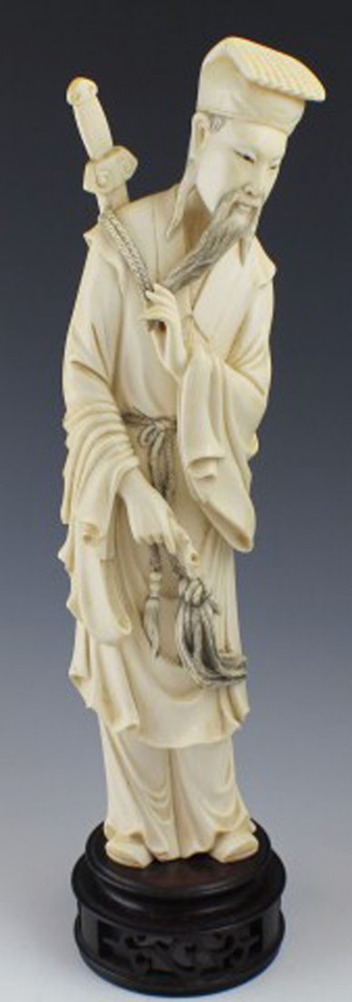CARVED IVORY FIGURE OF THE IMMORTAL LU TUNG-PIN: CARVED IVORY FIGURE OF THE IMMORTAL LU TUNG-PIN Carved Ivory Figure of The Immortal Lu Tung Pin, The Slayer of Monsters. Figure is depicted carrying a Cat o' Nine Tails in his right hand, stroking his