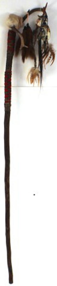 NATIVE AMERICAN WALKING STICK: NATIVE AMERICAN WALKING STICK Carved wooden walking stick with antlers on top and other decorative items such as bells, feathers, horse hair. Handle is wrapped with leather and red cloth. 69'' from bo