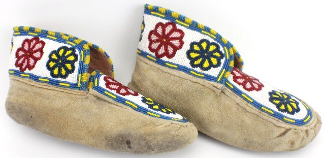 PAIR OF NATIVE AMERICAN - LAKOTA ADULT MOCCASINS: PAIR OF LAKOTA ADULT MOCCASINS Pair of Lakota Adult Moccasins. Red/Pink and Blue/Yellow Flower patterns on Chalk White background, outlined with Blue/Yellow. Minor cuts to bottom of soles. Size: 11 x 
