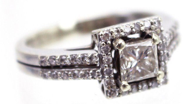 LADIES 18K WHITE GOLD DIAMOND ENGAGEMENT RING: LADIES 18K WHITE GOLD DIAMOND ENGAGEMENT RING Princess cut diamond engagement ring set in an 18K white gold halo style setting. 0.5 ct princess cut diamond of SI-2 clarity and J color, accented by 46