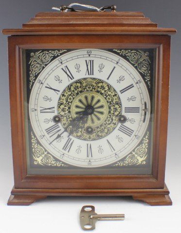 LINDEN MANTLE CLOCK: LINDEN MANTLE CLOCK Linden Mantle Clock with Roman Numeral face and gold designs. Made in West Germany with original key. Size: 10 x 9"
