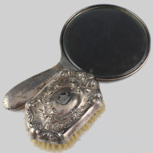 TIFFANY AND DERBY STERLING MIRROR AND BRUSH: TIFFANY AND DERBY STERLING MIRROR AND BRUSH Sterling silver hand mirror with Tiffany production stamps and a sterling brush with Derby hallmark. Weight: 499.6g Size: 4 1/2 - 10"