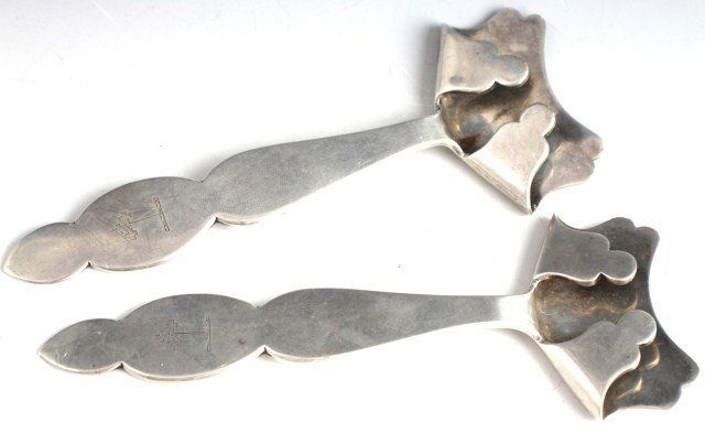 ENGLISH STERLING SILVER HOT PLATE HANDLES: ENGLISH STERLING SILVER HOT PLATE HANDLES Two silver hot plate holders/handles. Engraved coat of arms to the handle. Hallmarked for Sheffield 1903 and made by William Hutton & Sons Ltd. Size: 226g