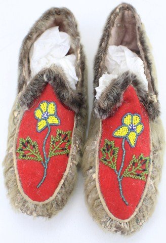 ADULT ALASKAN BEADED MOCCASINS: ADULT ALASKAN BEADED MOCCASINS Pair of Adult Alaskan Beaded Moccasins posibally Inuit. Deer Hide trimmed in fur. Yellow/Blue/White Flower designs with Blue Stem and Green Leaves. Fur is worn off the h