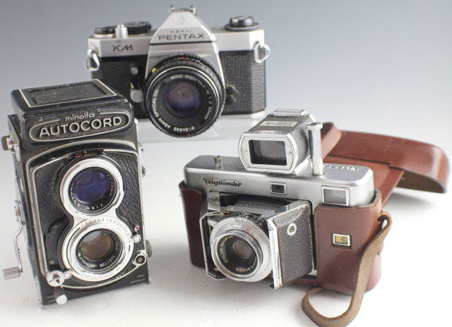 LOT OF 3 CAMERAS PENTAX MINOLTA AND VOIGTLANDER: LOT OF 3 CAMERAS PENTAX MINOLTA AND VOIGTLANDER Asahi Pentax KM with SMC Pentax-M 1:2 50mm. Voigtlander with Color-Skopar 1:3.5 50mm lens and brown leather case with strap. Minolta Autocord Citizen-MV