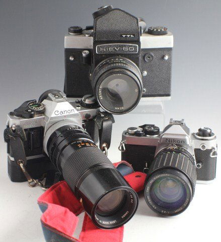 LOT OF 3 CAMERAS CANON KIEV & NIKON WITH LENSES: LOT OF 3 CAMERAS CANON KIEV & NIKON WITH LENSES Kiev 60 with Arsatc 80mm lens. Cannon AE1 Program with Canon zoom FD 100-200mm 1:5.6, comes with attached neck strap. Nikon with Nikura MC 1:3.5 35-135m