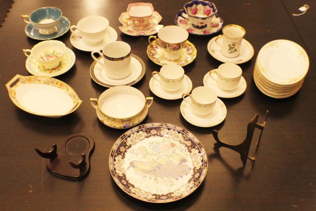 ASSORTED CHINA SET: ASSORTED CHINA SET This set features 11 teacup and saucer sets. 1 Nippon butter dish. 1 two-handled Nippon bowl. 6 oval Noritake plates. 1 Vanity plate featuring a peacock. 2 plate stands, one wooden,