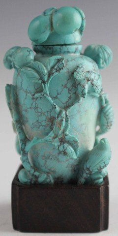 CARVED TURQUOISE SNUFF BOTTLE: CARVED TURQUOISE SNUFF BOTTLE Carved turquoise snuff bottle in the form of a vase surrounded by flowers and birds. Bottle is sat upon a .5" wooden base. , Size: 2.5" figure, Est. 100-200, Lot 30348