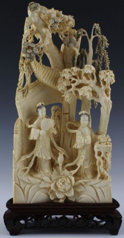 LARGE CHINESE ORNATELY CARVED IVORY GEISHA GARDEN SCENE: LARGE CHINESE ORNATELY CARVED IVORY GEISHA GARDEN SCENE Elegant carving of Chinese garden scene. Features two geisha in flowing robes standing in a garden, one with a fan the other holding a book. The