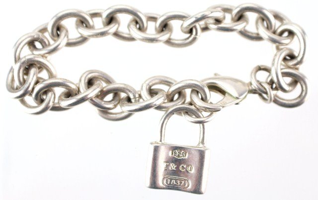 LADIES TIFFANY & CO STERLING LOCKET BRACELET: LADIES TIFFANY & CO STERLING LOCKET BRACELET Sterling silver bracelet by Tiffany & Co. Features lock charm stamped "925 T & CO 1837". Weight: 1 ozt, Size: 7.5", Est. 100-200, Lot 30540