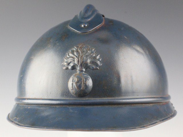 WWI FRENCH M15 ADRIAN TRENCH HELMET: WWI FRENCH M15 ADRIAN TRENCH HELMET A model 1915 French Adrian type helmet, painted dark blue for later trench infantry warfare. Raised center comb with ventilation holes and flaming bomb badge with "