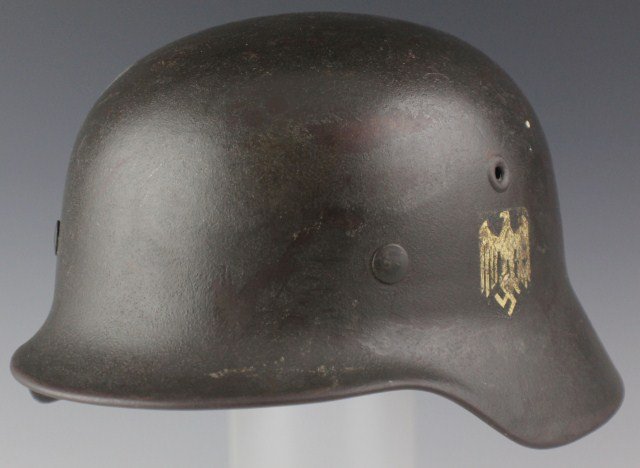 WWII GERMAN M40 HELMET AND LINER: WWII GERMAN M40 HELMET AND LINER A German model 1940 WWII combat helmet with silver eagle and swastika decal mostly intact. Riveted air vents and swivel bales for the chin straps. Leather liner in goo