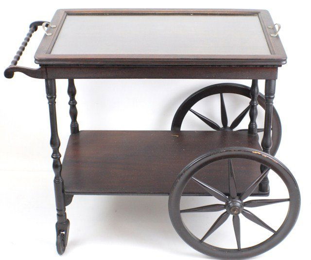 OAK TEA CART WITH GLASS TRAY: OAK TEA CART WITH GLASS TRAY An oak tea cart with glass serving tray. Tray has two handles, light scratches to glass. Large wheels measure 16 1/2" in diameter and have rubber rings for absorbing shock