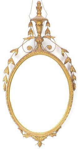 CARVED AND GILT PAINTED OVAL WALL MIRROR: CARVED AND GILT PAINTED OVAL WALL MIRROR A large hand carved wooden oval hanging wall mirror with girl paint. No scratches to glass, some areas of paint are showing through. Mirror is crowned by a fou