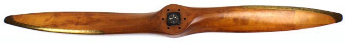 LARGE WOODEN BRASS FITTED AIR CRAFT PROPELLER: LARGE WOODEN BRASS FITTED AIR CRAFT PROPELLER A large laminated wooden propeller of a symmetrical leading and trailing edge blade design. Riveted brass fittings leading towards the hub. In the hub the
