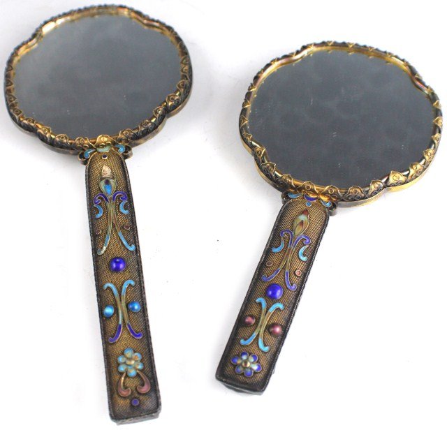 TWO CHINESE JADE & ENAMEL HAND MIRRORS: A late 19th century hand mirror in silver and gilt metal decorated with colored enamel and backed with a celadon jade disc and handle back. Together with a second, similar example, smaller in size. Si