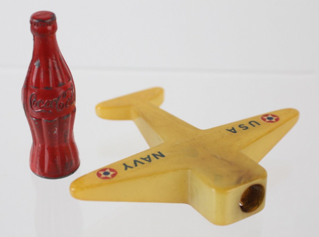 VINTAGE PENCIL SHARPENERS COCA-COLA & BAKELITE: VINTAGE PENCIL SHARPENERS COCA-COLA & BAKELITE Lot of two vintage pencil sharpeners. One Coca-cola pencil sharpener, 2". One Bakelite Navy USA pencil sharpener, 2.25 x 2.7". Size: N/A, Est. 25-50, Lot