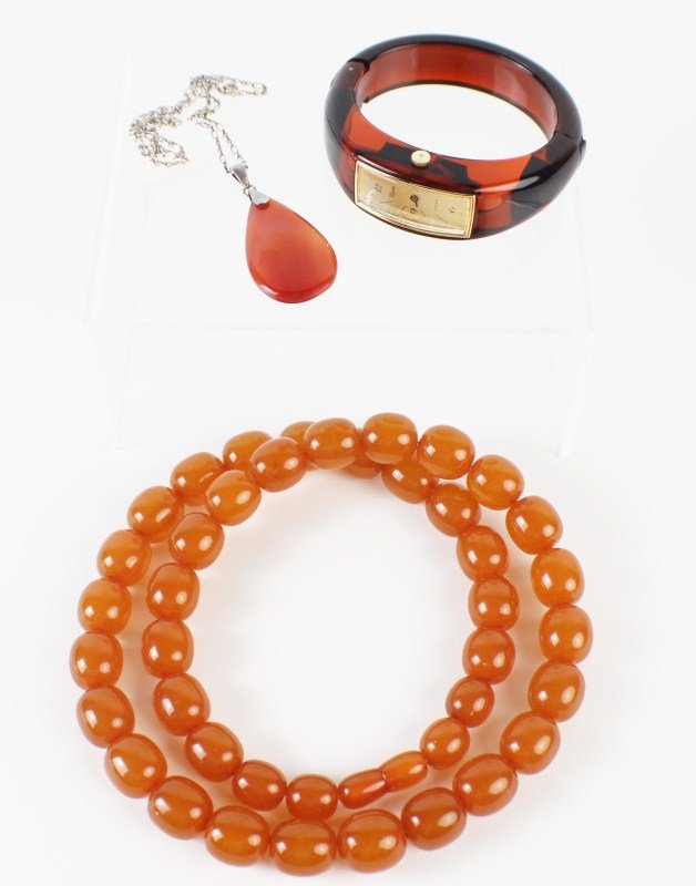 CARNELIAN NECKLACE WITH COSTUME JEWELRY: CARNELIAN NECKLACE WITH COSTUME JEWELRY Ladies sterling chain with tear shaped carnelian pendant, 40mm. Ladies 26" strand of 16mm faux amber beads. Ladies vintage Capri bangle watch, 2.25" diameter. S