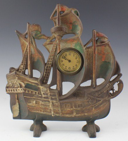 CAST IRON SHIP DOORSTOP CLOCK: CAST IRON SHIP DOORSTOP CLOCK Cast iron doorstop in the shape of a ship with clock. Unknown maker's mark to back. Paint loss. Key wind clock, does not wind. Size: 11.5" tall, Est. 50-100, Lot: 32405