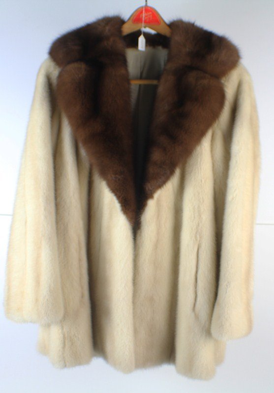 CREAM COLORED MINK COAT WITH BROWN COLLAR: CREAM COLORED MINK COAT WITH BROWN COLLAR Cream colored mink coat, with brown collar. Lined in cream colored silk with embroidered design. There are slits, possibly for a belt or a sash. Inside silk h