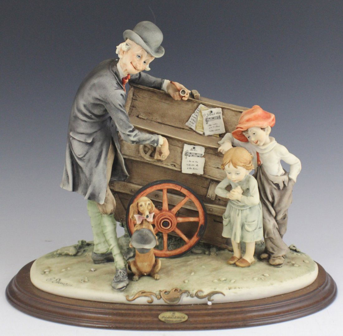 ARMANI CAPODIMONTE THE ORGAN GRINDER 267C: ARMANI CAPODIMONTE THE ORGAN GRINDER 267C Porcelain figurine, The Organ Grinder by Giuseppe Armani. On wooden base, marked with Capidimonte "N" Crown Pottery Mark. Made in Italy. No box, only foam. Si
