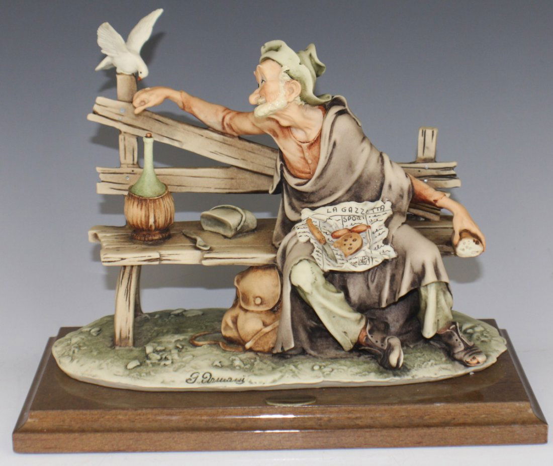 ARMANI CAPODIMONTE TRAMP FEEDING DOVE 0218C: ARMANI CAPODIMONTE TRAMP FEEDING DOVE 0218C Porcelain figurine, Tramp Feeding Dove by Giuseppe Armani. On wooden base, marked with Capidimonte "N" Crown Pottery Mark. Made in Italy. Size: 8" (with bas