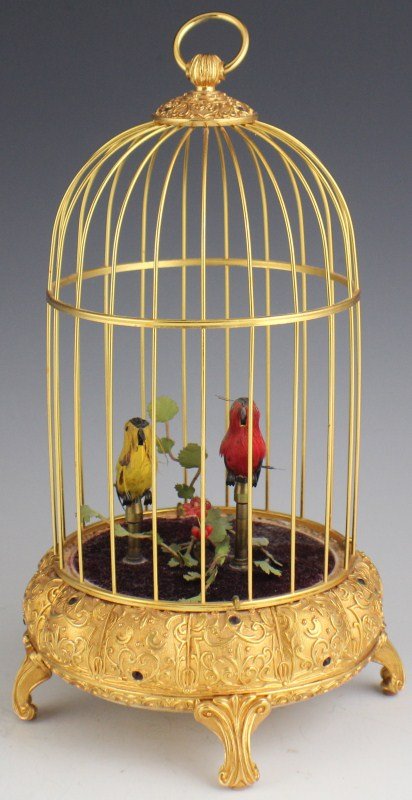 W GERMANY ELPA SINGING BIRD CAGE 2 BIRD AUTOMATON: W GERMANY ELPA SINGING BIRD CAGE 2 BIRD AUTOMATON Singing bird cage automaton. 2 birds that sing, rotate, and move their beaks and tails. In gold colored cage adorned with garnet colored stones. Botto