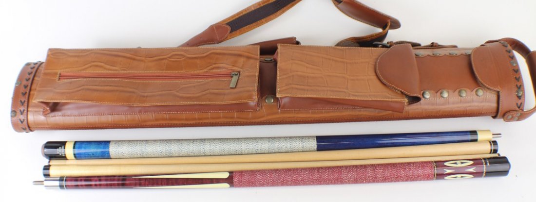 2 POOL CUES IN LEATHER CASE MALI AND HUEBLER: 2 POOL CUES IN LEATHER CASE MALI AND HUEBLER Two, two piece pool cues. Huebler USA cue is a dark blue with white linen wrap. Mali is brown with ivory color accents and red linen wrap. Cues are in a li