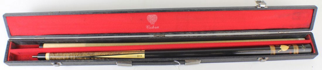 DH04 MEUCCI POOL CUE IN WOODEN COBRA CASE: DH04 MEUCCI POOL CUE IN WOODEN COBRA CASE Meucci two piece cues and with knight and sword inlay. Comes in black Cobra case, one latch is broken on case. Size: 58" Est. $ 100-200 Lot 31677