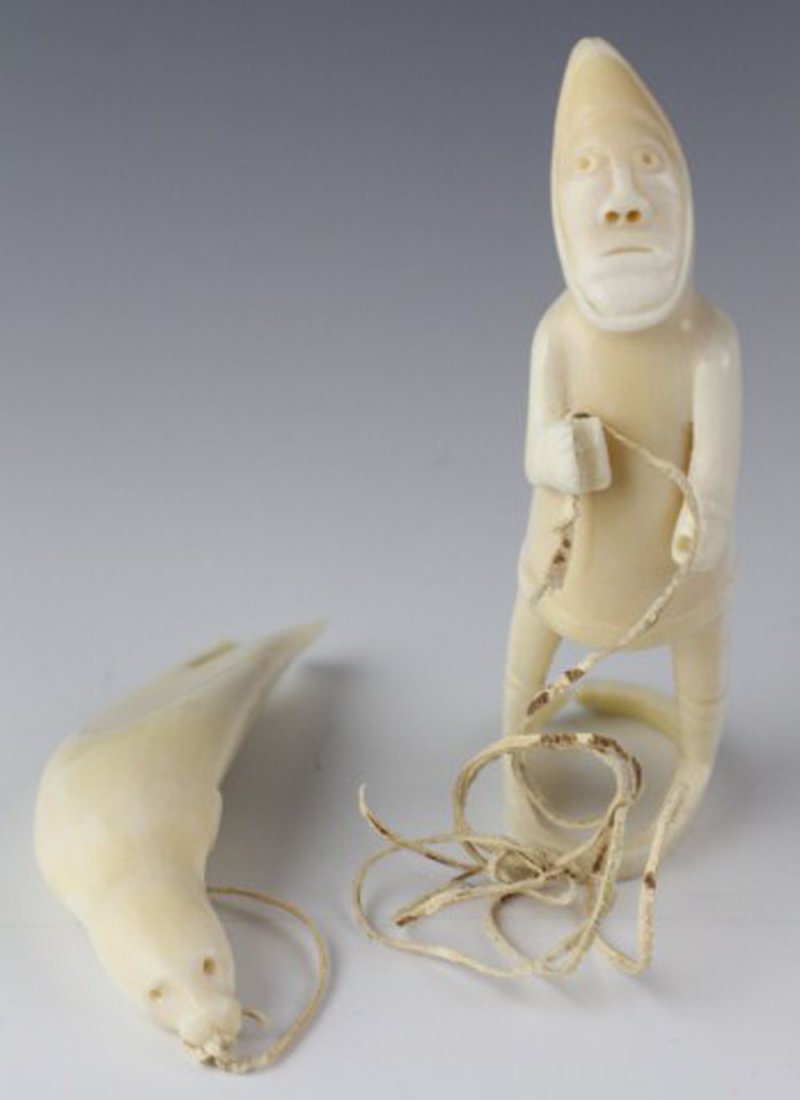 GREENLAND INUIT TUPILAK CARVED IVORY HUNTER FIGURE: GREENLAND INUIT TUPILAK CARVED IVORY HUNTER FIGURE a native Inuit hunter with spear dragging seal. Carved from whale's tooth. String to seal is broken. Size: 4.5" Est. $100-200 Lot: 33071