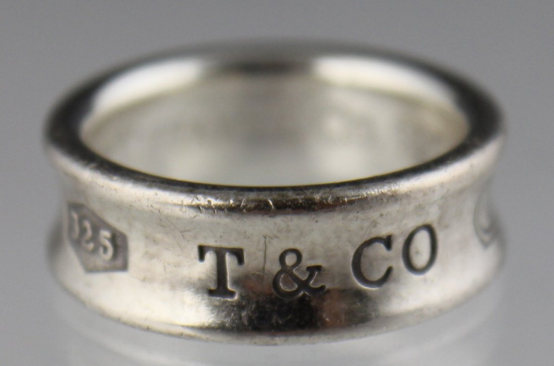 TIFFANY & CO. STERLING SILVER BAND RING: TIFFANY & CO. STERLING SILVER BAND RING 6mm wide Tiffany & Co. convex sterling silver band. Weight: 6.8g Size: 5.50 Est. $50-100 Lot: 33105b