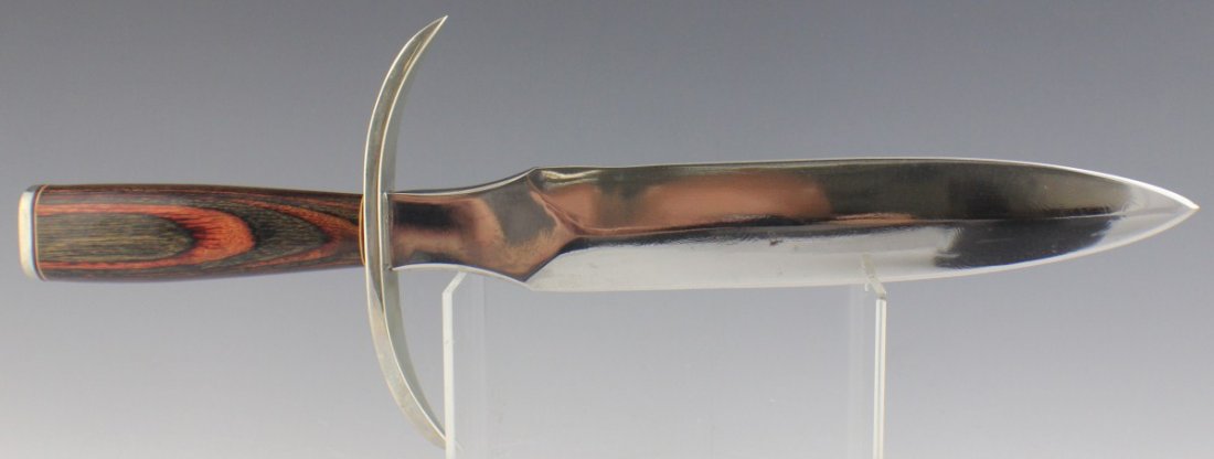 LARGE DOUBLE EDGED DAGGER BY CARMON: LARGE DOUBLE EDGED DAGGER BY CARMON Double edged custom polished steel knife. Made by Carmon. White metal cross guard with polished wood handle. Blade is 10" in length, 14.75" overall. No sheath. Size