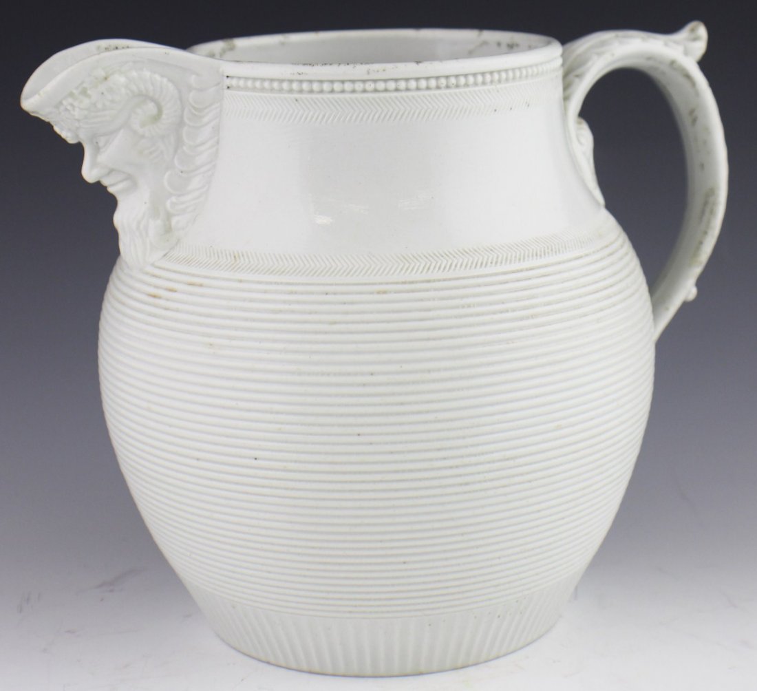 MINTON SALT GLAZE PITCHER & FOOTED SERVING BOWL: MINTON SALT GLAZE PITCHER & FOOTED SERVING BOWL A salt glazed pitcher by Minton. Spout features Dionysian head. Some surface wear. Footed serving bowl with lid, transfer ware, damage to one foot. Size