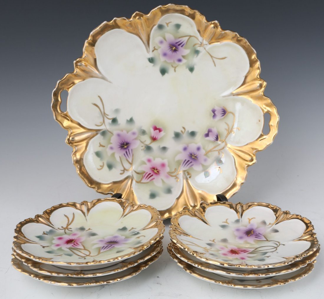 GILT PORCELAIN CAKE STAND AND PLATES: GILT PORCELAIN CAKE STAND AND PLATES Made in Germany, cake stand with floral motif and gilt accents. Comes with six matching plates.