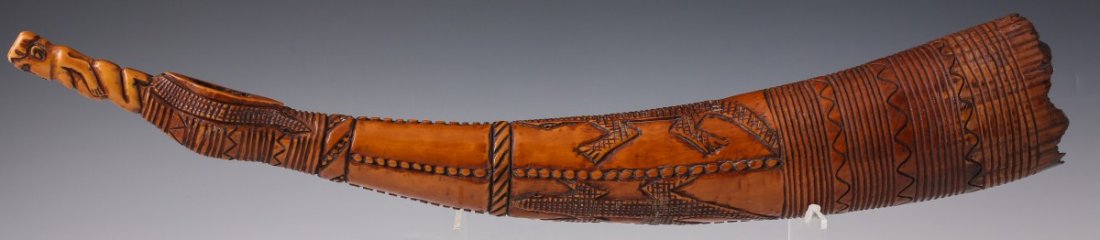 AFRICAN CARVED IVORY FIGURAL OLIPHANT LIZARDS: AFRICAN CARVED IVORY FIGURAL OLIPHANT LIZARDS An African carved ivory oliphant, or side trumpet. Repeating wave decor and rings have as well as prone lizards have been carved into surface. Diamond sha