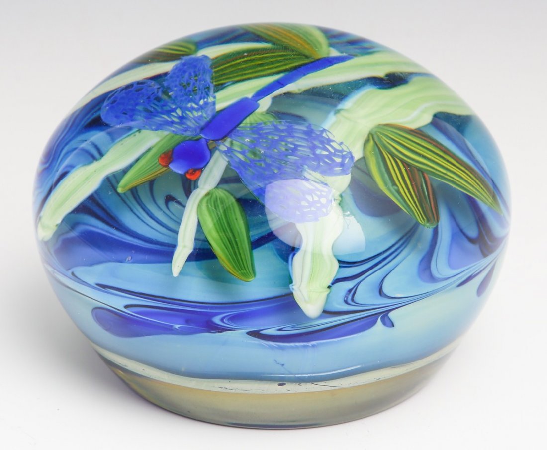 JUSTIN LUNDBERG ART GLASS PAPERWEIGHT - SIGNED: JUSTIN LUNDBERG ART GLASS PAPERWEIGHT - SIGNED Limited edition. Floral design. Blue background with green flowers and dragonfly. Signed : (Justin Lundberg signature) 11/02 8/25. Foil label attached : 